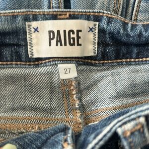 PAIGE medium wash distressed jean shorts.
